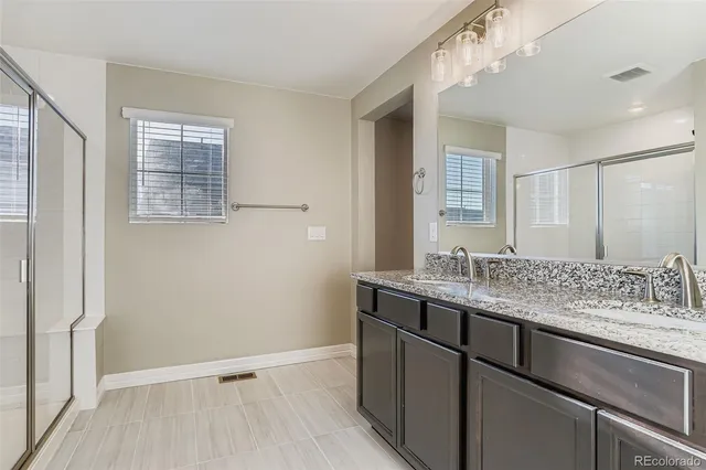 a bathroom with a granite countertop sink and shower