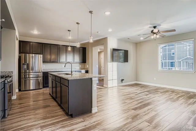 a large kitchen with stainless steel appliances granite countertop a stove and a refrigerator