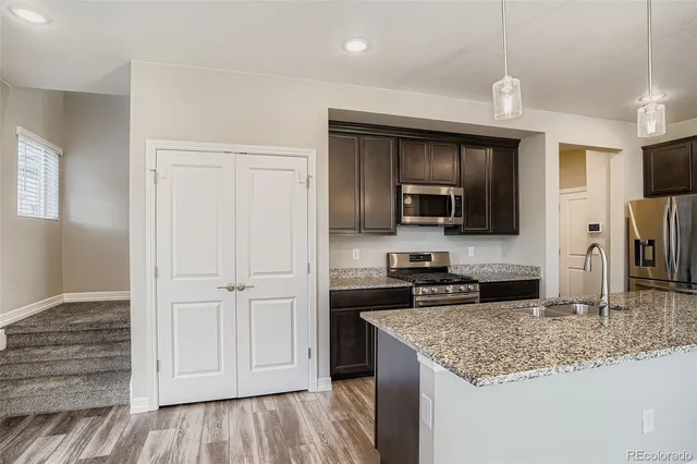 a kitchen with stainless steel appliances granite countertop a refrigerator microwave and sink