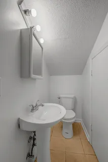 a bathroom with a sink a toilet and mirror