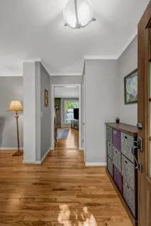a view of a hallway with wooden floor and staircase