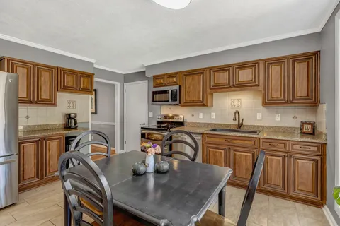 a kitchen with a table chairs microwave and cabinets