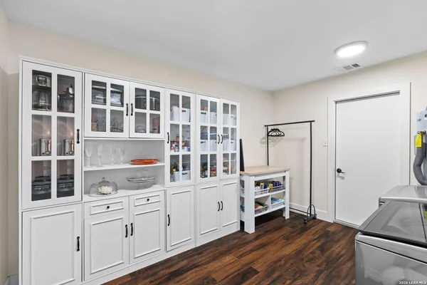 a kitchen with stainless steel appliances white cabinets and wooden floors