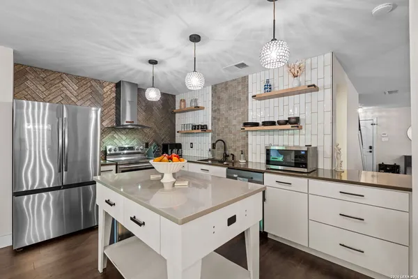 a kitchen with a sink stainless steel appliances a counter space and wooden floor