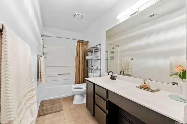 a bathroom with a double vanity sink toilet mirror and bathtub