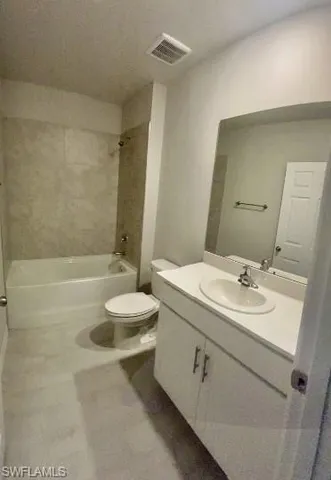 a bathroom with a granite countertop sink a toilet a mirror and bathtub