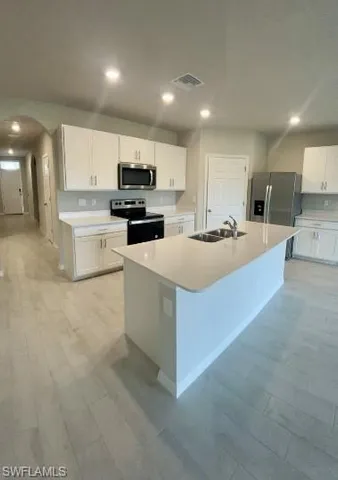 a kitchen with kitchen island a sink stove and refrigerator