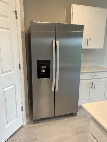 a kitchen with metallic refrigerator freezer and a dishwasher with wooden floor