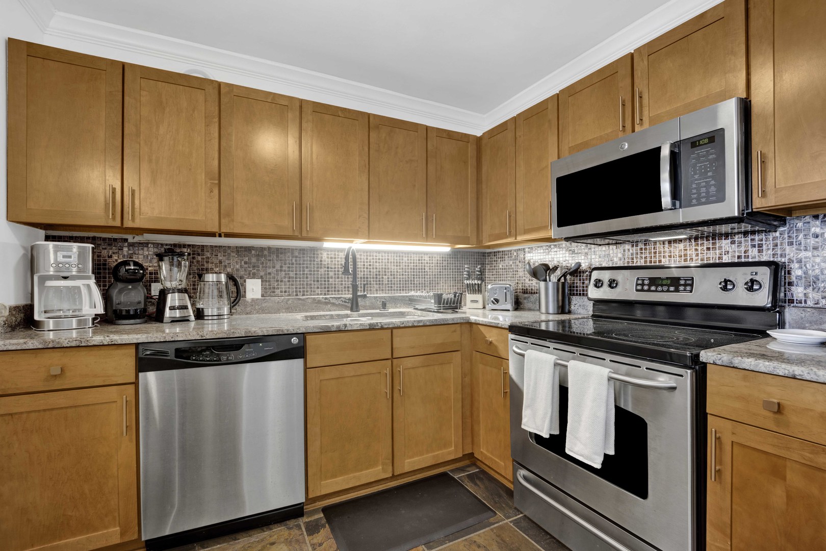 30 East Huron Street, Unit 3206 Chicago, IL 60611 - Photo 8 of 29 a kitchen with stainless steel appliances granite countertop a sink stove and microwave