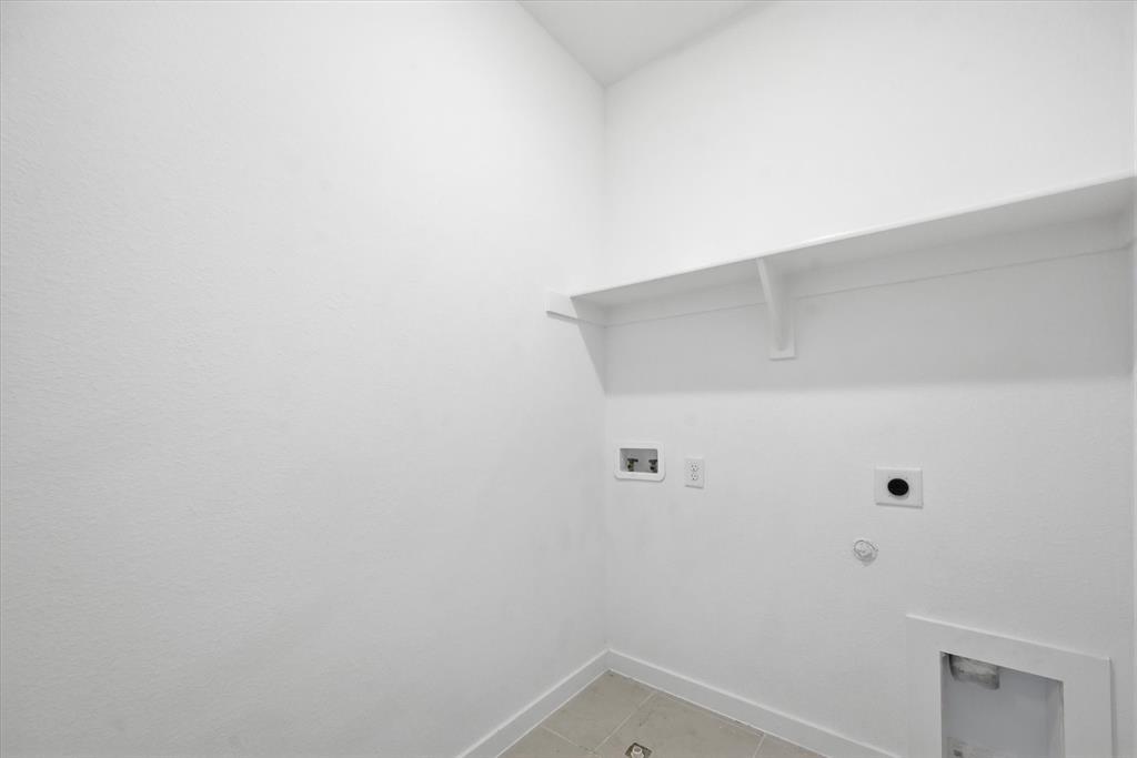 1153 Queensdown Way Forney, TX 75126 - Photo 14 of 26 Utility space featuring a built-in shelf, appliance hookups, and neutral-toned floor tiling