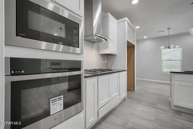 a kitchen with stainless steel appliances granite countertop a stove and a microwave