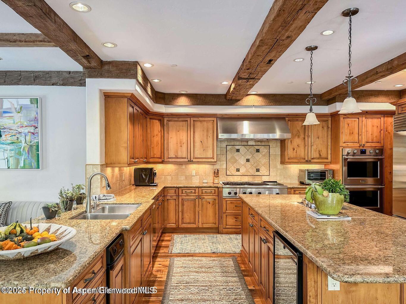 1540 Silver King Drive Aspen, CO 81611 - Photo 8 of 32 a kitchen with stainless steel appliances granite countertop a sink a stove and a wooden floors
