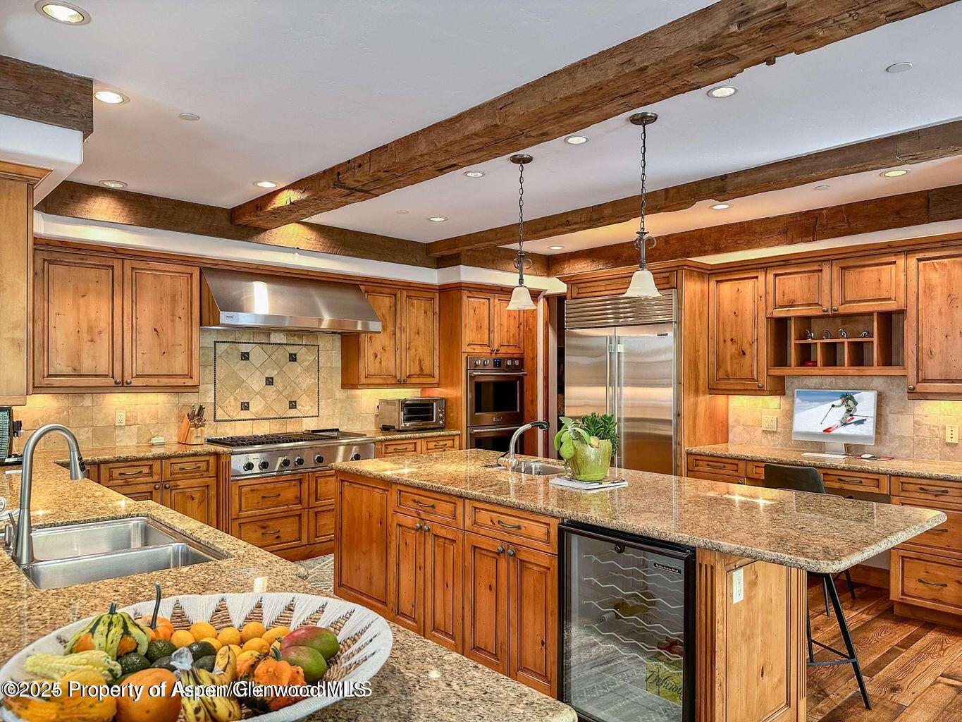 1540 Silver King Drive Aspen, CO 81611 - Photo 9 of 32 a kitchen with stainless steel appliances granite countertop a sink a stove and a wooden cabinets