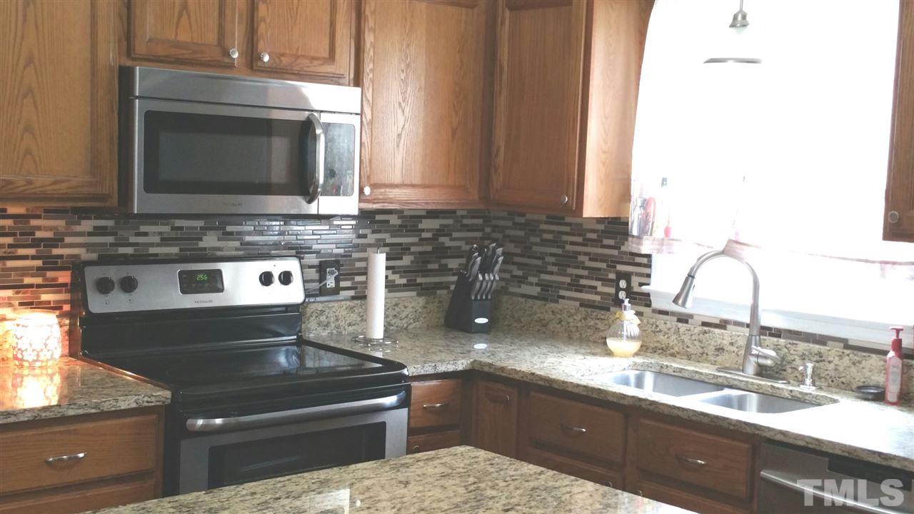 4401 Wolftrap Road Raleigh, NC 27616 - Photo 7 of 18 a kitchen with granite countertop a sink and a stove
