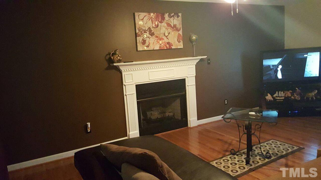 4401 Wolftrap Road Raleigh, NC 27616 - Photo 10 of 18 a living room with furniture a fireplace and a table