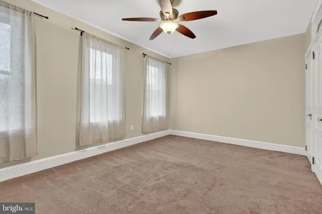 an empty room with chandelier fan
