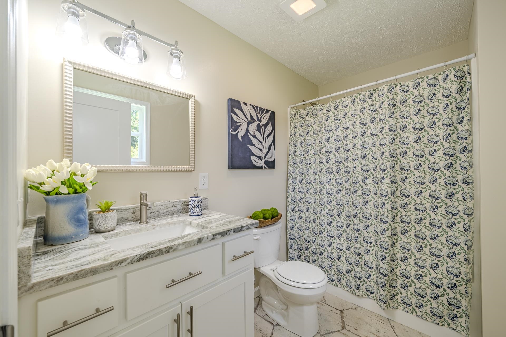 231 Clausel Lane Adamsville, TN 38310 - Photo 13 of 32 a bathroom with a granite countertop sink a toilet and a mirror