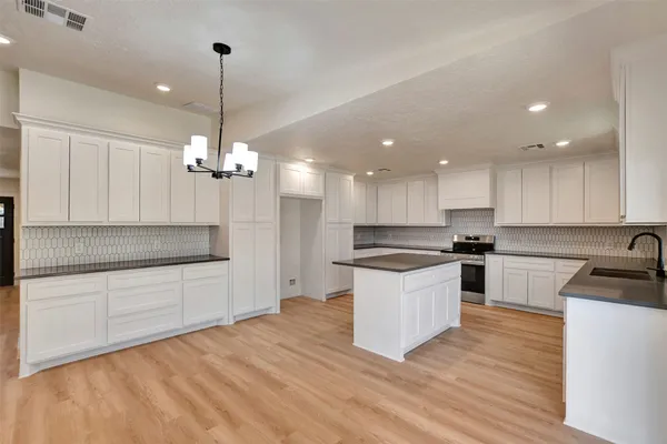 an empty room with windows and ceiling fan