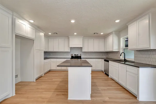 a kitchen with stainless steel appliances granite countertop a sink and cabinets