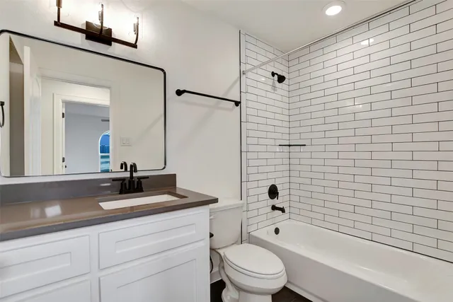 a bathroom with a toilet a sink a mirror and bathtub