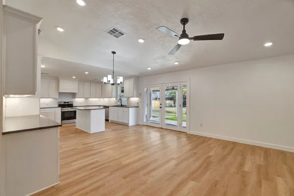 a view of a livingroom with wooden floor and a ceiling fan