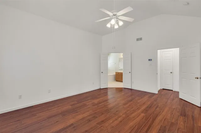 a view of empty room with wooden floor
