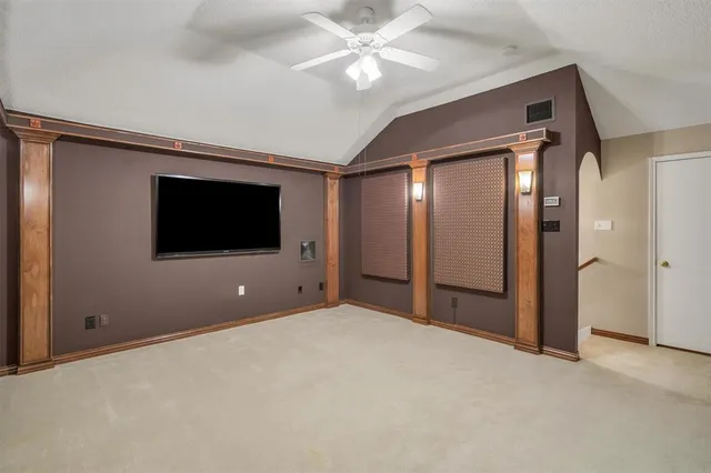 a view of an empty room with window and a ceiling fan