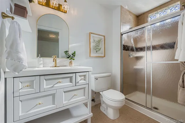 a bathroom with a toilet a sink and glass door