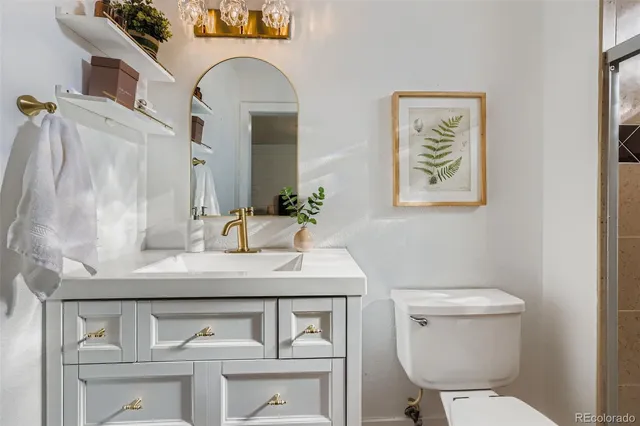 a bathroom with a toilet a sink and mirror