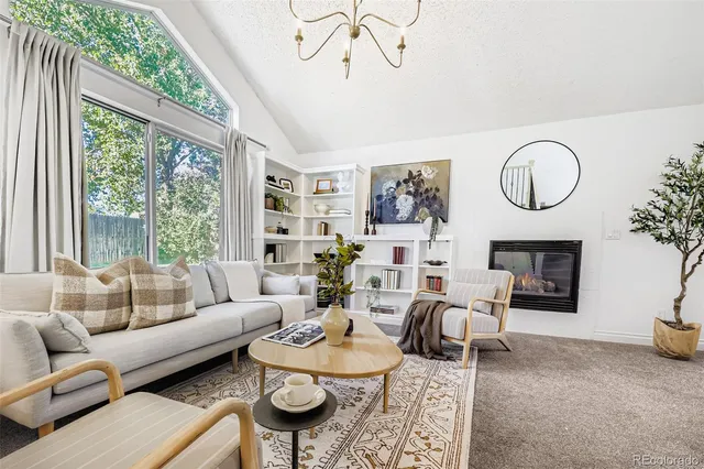 a living room with furniture a fireplace and a large window