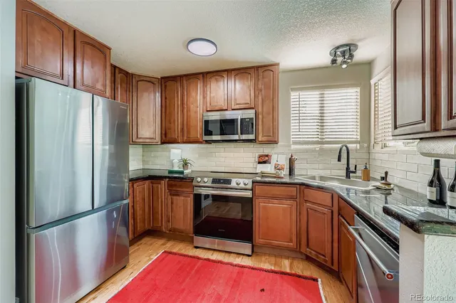 a kitchen with stainless steel appliances granite countertop a refrigerator stove microwave and sink