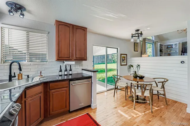 a dining hall with granite countertop a sink a stove a dining table and chairs