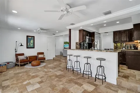 a kitchen with stainless steel appliances lots of white furniture a refrigerator a stove a sink dishwasher and white cabinets with wooden floor