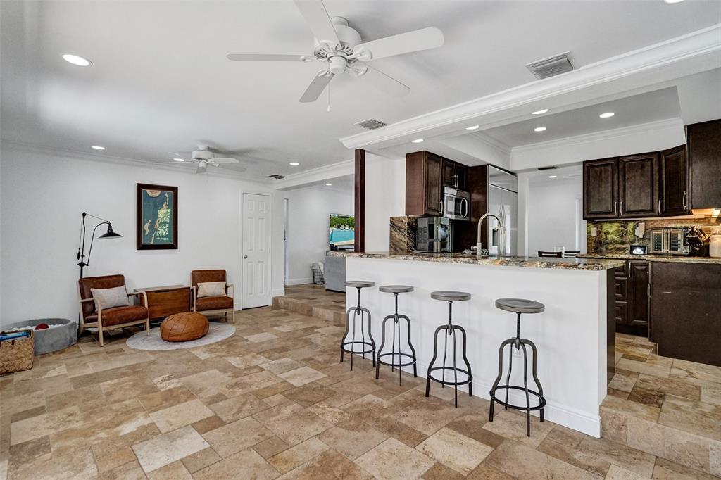 2185 Northeast 61st Court Fort Lauderdale, FL 33308 - Photo 11 of 49 a kitchen with stainless steel appliances lots of white furniture a refrigerator a stove a sink dishwasher and white cabinets with wooden floor