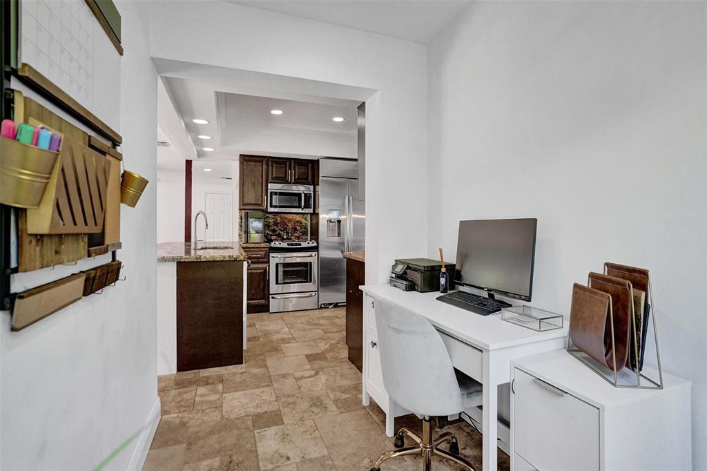 2185 Northeast 61st Court Fort Lauderdale, FL 33308 - Photo 27 of 49 a view of a workspace with furniture and flat screen tv
