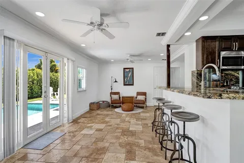 a dining room with furniture a rug and a floor to ceiling window