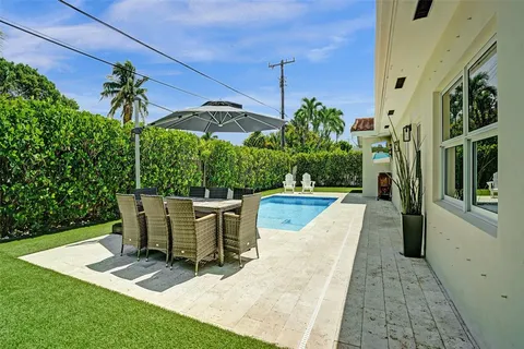 a patio with swimming pool table and chairs