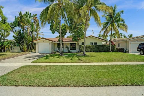 a front view of a house with a garden and trees