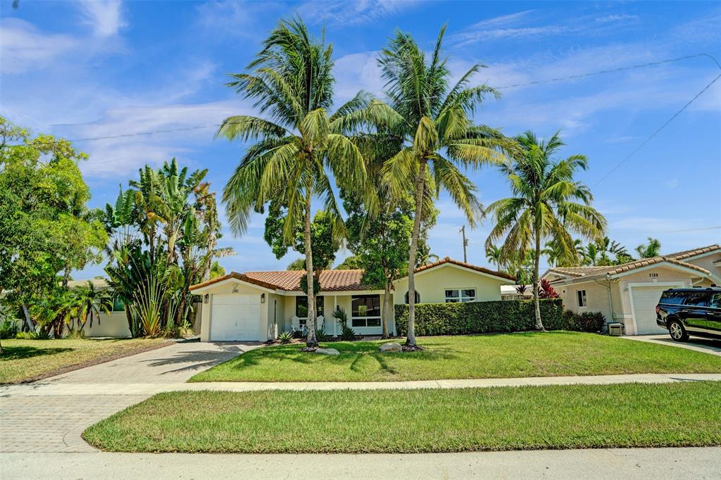2185 Northeast 61st Court Fort Lauderdale, FL 33308 - Photo 47 of 49 a front view of a house with a garden and trees