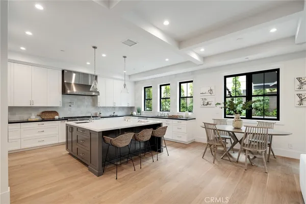 a kitchen with white cabinets and a window