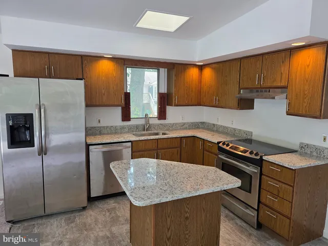 a kitchen with a stove a sink and a refrigerator