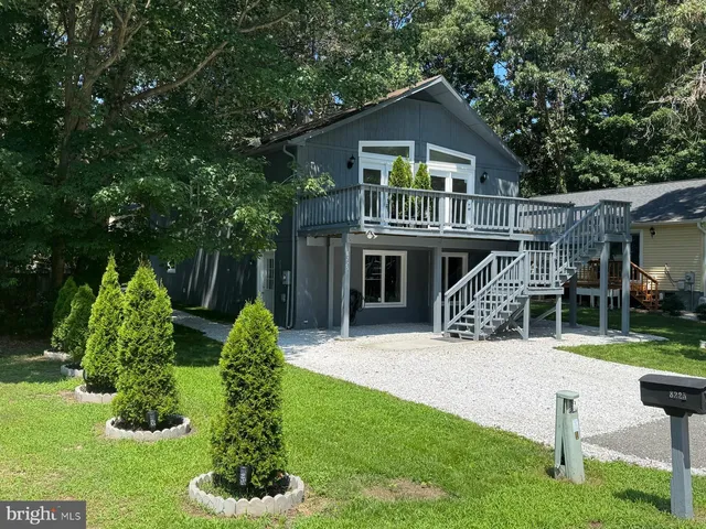 a front view of a house with a yard and potted plants