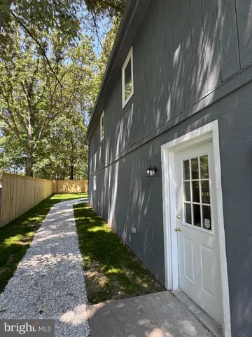 a view of a pathway of a house with backyard and trees