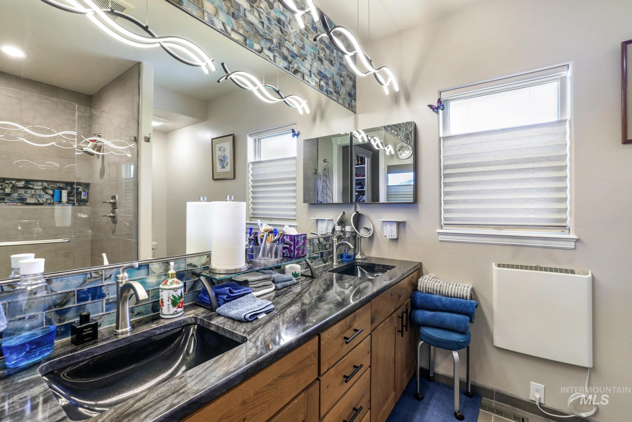 100 Olympic Road Jerome, ID 83338 - Photo 21 of 50 Dual vanity with integrated black sinks, complemented by a stone countertop and wood-finish cabinetry