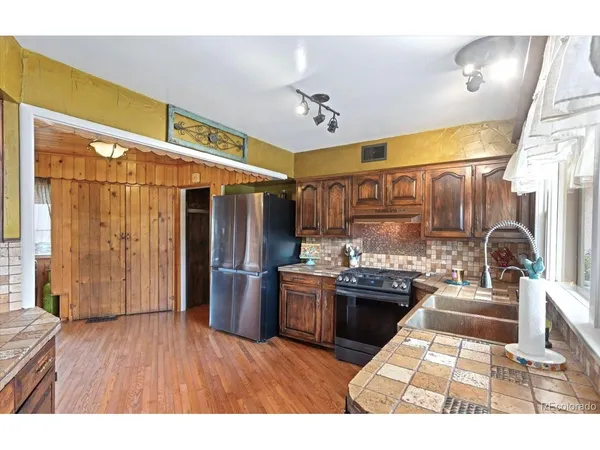 a living room with stainless steel appliances kitchen island granite countertop furniture a rug kitchen view and a chandelier