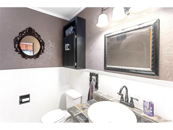 a bathroom with a toilet a sink and mirror