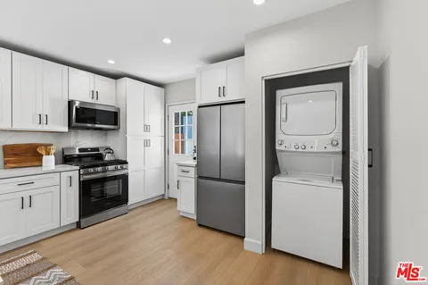 a kitchen with stainless steel appliances granite countertop a refrigerator a stove top oven a sink and dishwasher