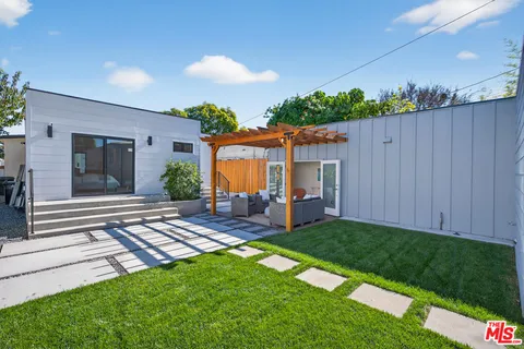 a view of a backyard with couches plants and large tree