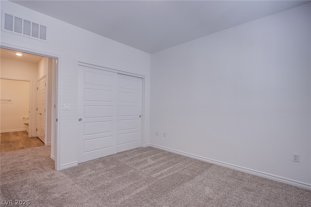 2555 Hampton Road, Unit 8201 Henderson, NV 89052 - Photo 25 of 33 Plush carpeting and modern sliding closet doors anchor this versatile secondary bedroom space.