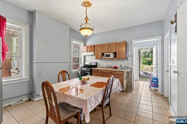 a kitchen with a table chairs a sink dishwasher stove and cabinets